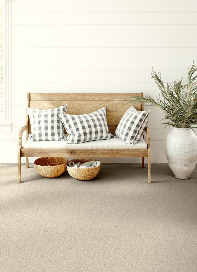durable carpets in an entryway with a bench and a potted plant